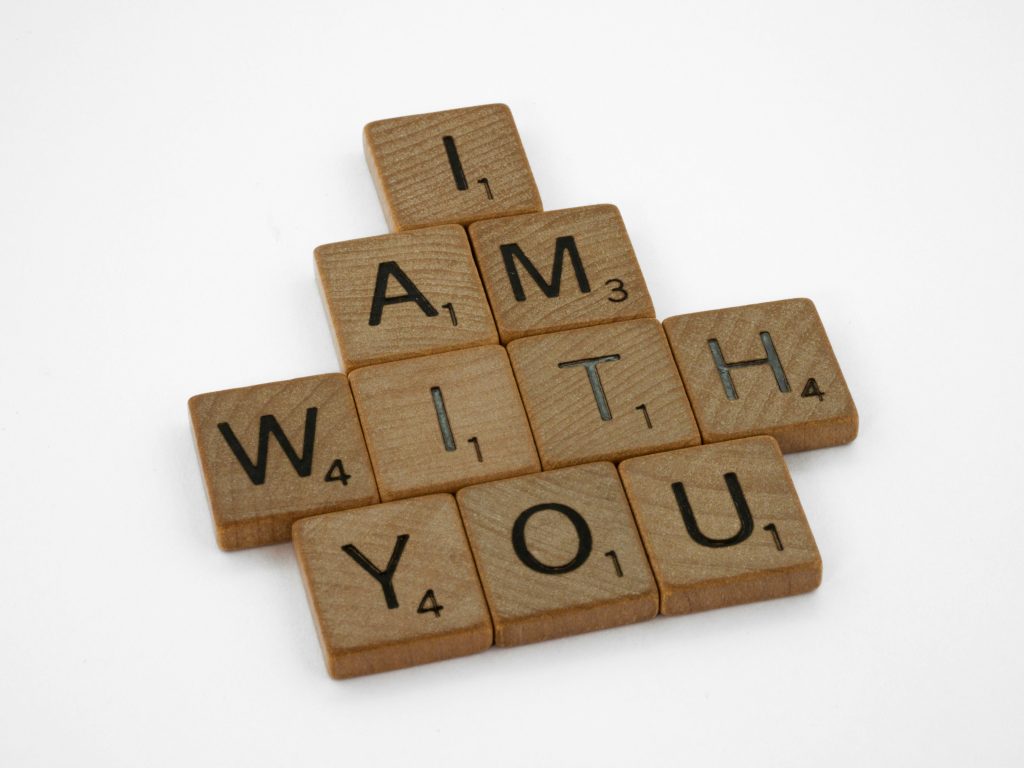 Scrabble tiles spelling 'I am with you' on a white background.