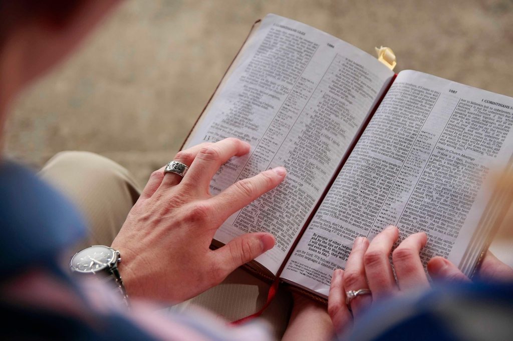 A couple, each with their left hand on the open Bible